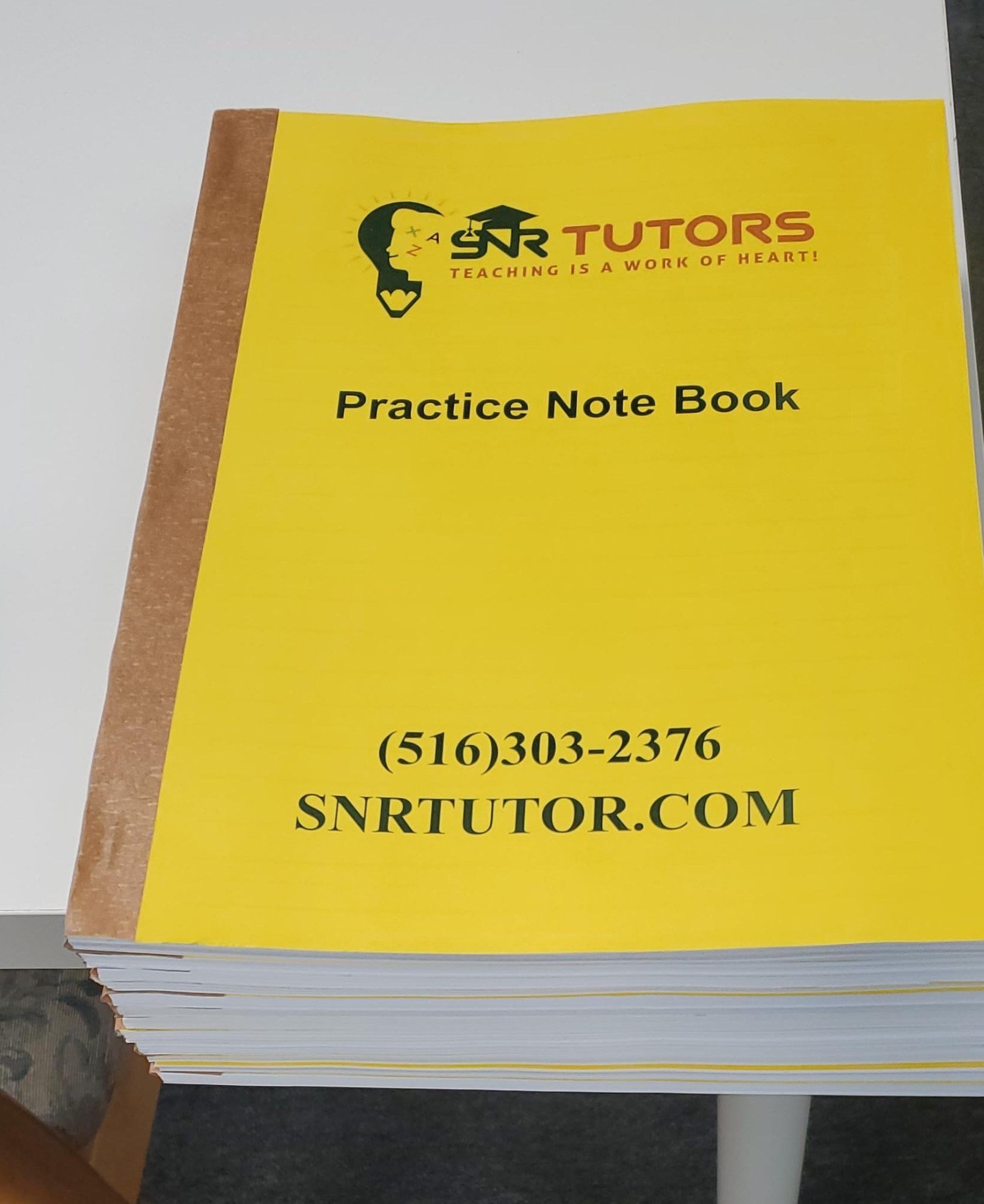 A stack of SNR Tutors custom Practice Note Books